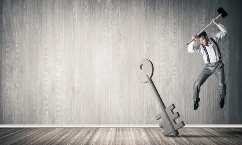 Breaking through access concept with man in room crashing concrete key Stock Photos