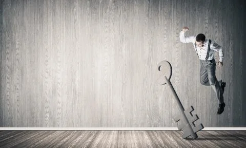 Breaking through access concept with man in room crashing concrete key Stock Photos
