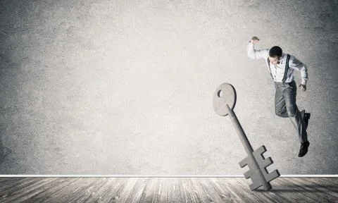 Breaking through access concept with man in room crashing concrete key Stock Photos