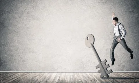 Breaking through access concept with man in room crashing concrete key Stock Photos