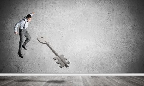 Breaking through access concept with man in room crashing concrete key 스톡 사진