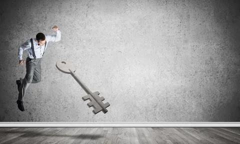 Breaking through access concept with man in room crashing concrete key 스톡 사진