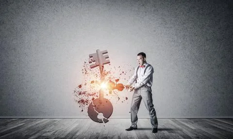 Breaking through access concept with man in room crashing concrete key 스톡 사진