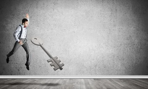 Breaking through access concept with man in room crashing concrete key Stock Photos