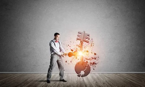 Breaking through access concept with man in room crashing concrete key 스톡 사진