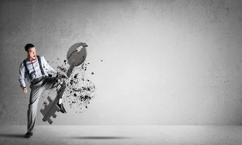 Breaking through access concept with man in room crashing concrete key 스톡 사진