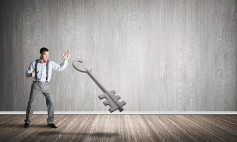 Breaking through access concept with man in room crashing concrete key Stock Photos