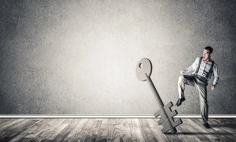 Breaking through access concept with man in room crashing concrete key 스톡 사진