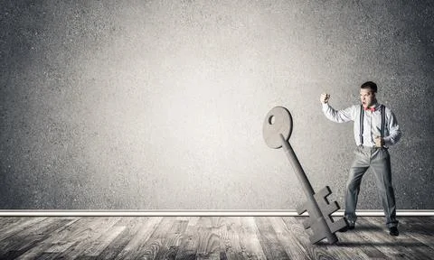 Breaking through access concept with man in room crashing concrete key Stock Photos