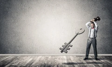 Breaking through access concept with man in room crashing concrete key 写真素材