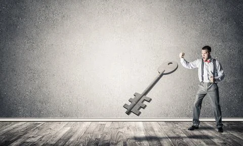 Breaking through access concept with man in room crashing concrete key Stock Photos