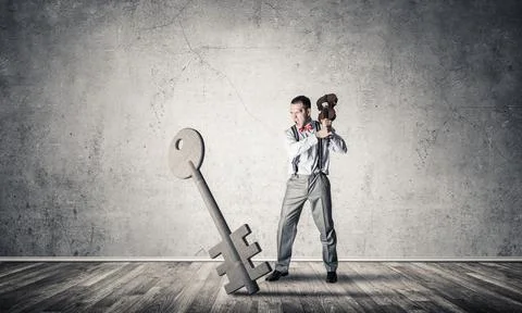 Breaking through access concept with man in room crashing concrete key 写真素材