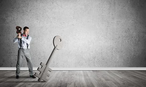 Breaking through access concept with man in room crashing concrete key Stock Photos