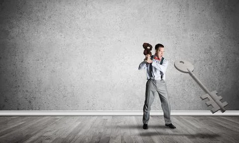 Breaking through access concept with man in room crashing concrete key Stock Photos