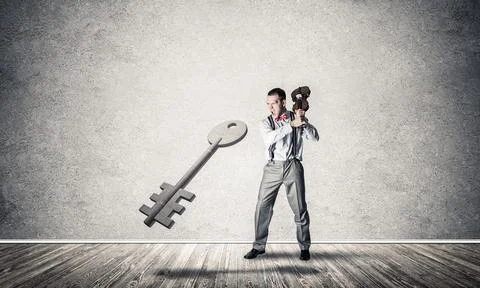 Breaking through access concept with man in room crashing concrete key 写真素材