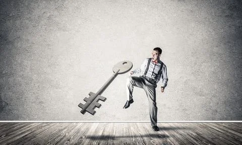 Breaking through access concept with man in room crashing concrete key 스톡 사진