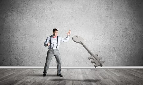 Breaking through access concept with man in room crashing concrete key Stock Photos