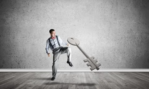 Breaking through access concept with man in room crashing concrete key 스톡 사진