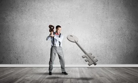 Breaking through access concept with man in room crashing concrete key Stock Photos