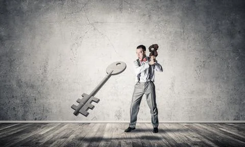 Breaking through access concept with man in room crashing concrete key 写真素材