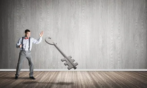 Breaking through access concept with man in room crashing concrete key Det... 写真素材