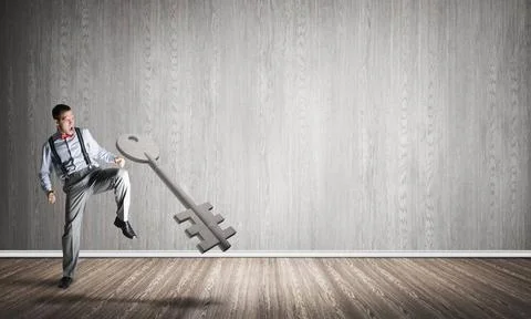 Breaking through access concept with man in room crashing concrete key Det... 스톡 사진