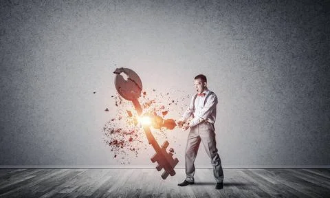 Breaking through access concept with man in room crashing concrete key Det... 写真素材
