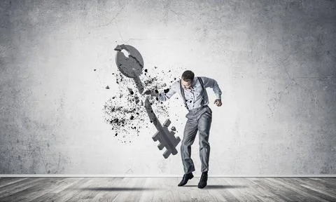 Breaking through access concept with man in room crashing concrete key Det... 스톡 사진