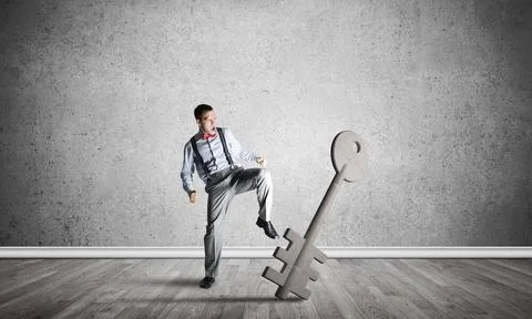 Breaking through access concept with man in room crashing concrete key Det... 写真素材