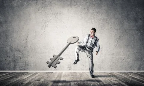 Breaking through access concept with man in room crashing concrete key 스톡 사진