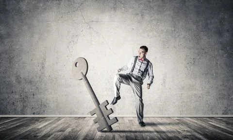Breaking through access concept with man in room crashing concrete key Stock Photos