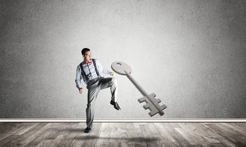 Breaking through access concept with man in room crashing concrete key 스톡 사진