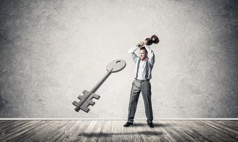 Breaking through access concept with man in room crashing concrete key 스톡 사진
