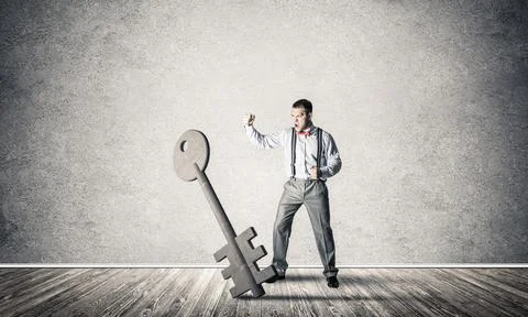 Breaking through access concept with man in room crashing concrete key Stock Photos