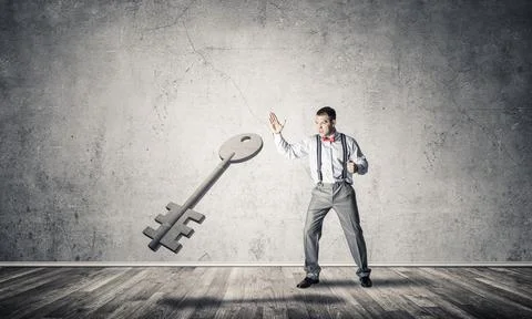 Breaking through access concept with man in room crashing concrete key 스톡 사진