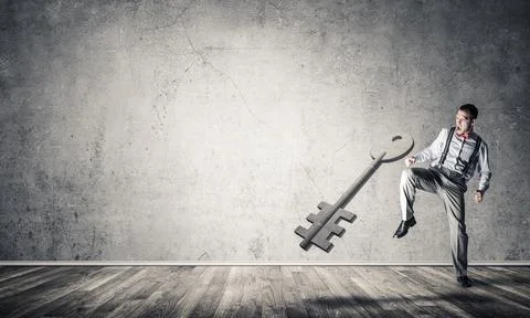 Breaking through access concept with man in room crashing concrete key Stock Photos