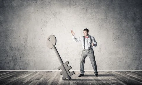 Breaking through access concept with man in room crashing concrete key Stock Photos