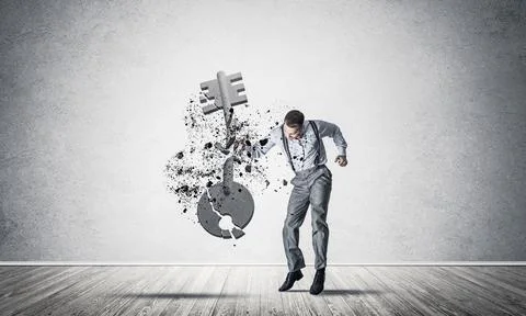 Breaking through access concept with man in room crashing concrete key Stock Photos