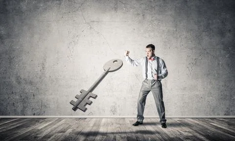 Breaking through access concept with man in room crashing concrete key 스톡 사진