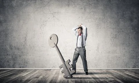 Breaking through access concept with man in room crashing concrete key 스톡 사진