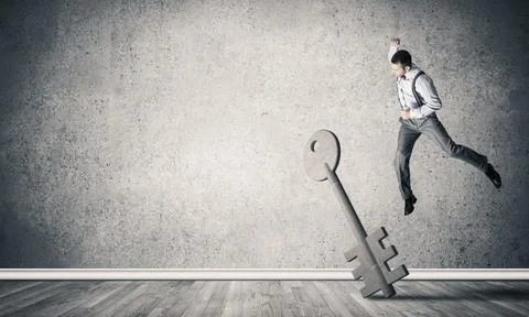 Breaking through access concept with man in room crashing concrete key 스톡 사진