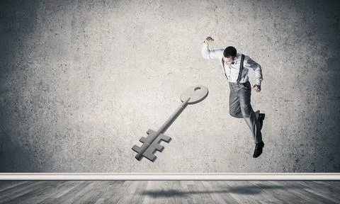 Breaking through access concept with man in room crashing concrete key 스톡 사진