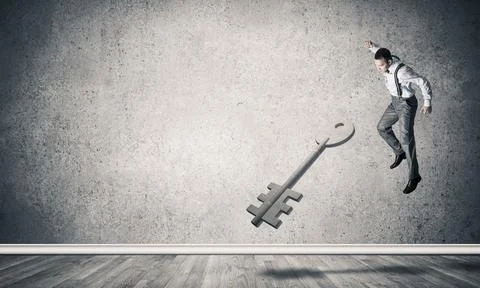 Breaking through access concept with man in room crashing concrete key Stock Photos