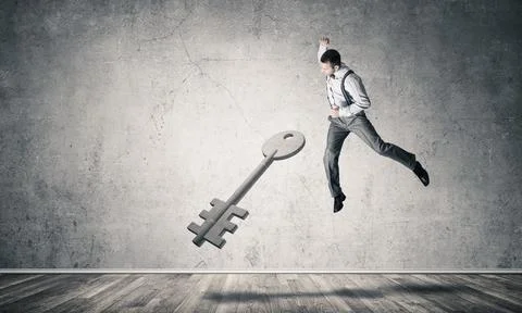 Breaking through access concept with man in room crashing concrete key Stock Photos