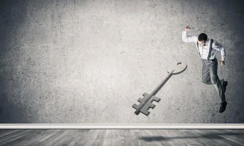Breaking through access concept with man in room crashing concrete key 스톡 사진