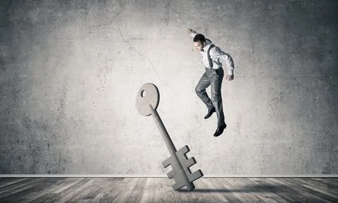 Breaking through access concept with man in room crashing concrete key Stock Photos