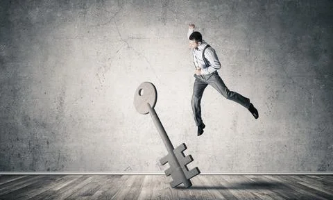 Breaking through access concept with man in room crashing concrete key Stock Photos
