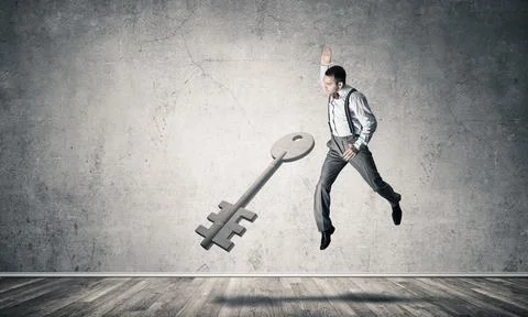 Breaking through access concept with man in room crashing concrete key 스톡 사진