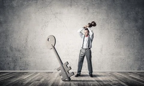 Breaking through access concept with man in room crashing concrete key Stock Photos