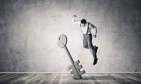 Breaking through access concept with man in room crashing concrete key 스톡 사진